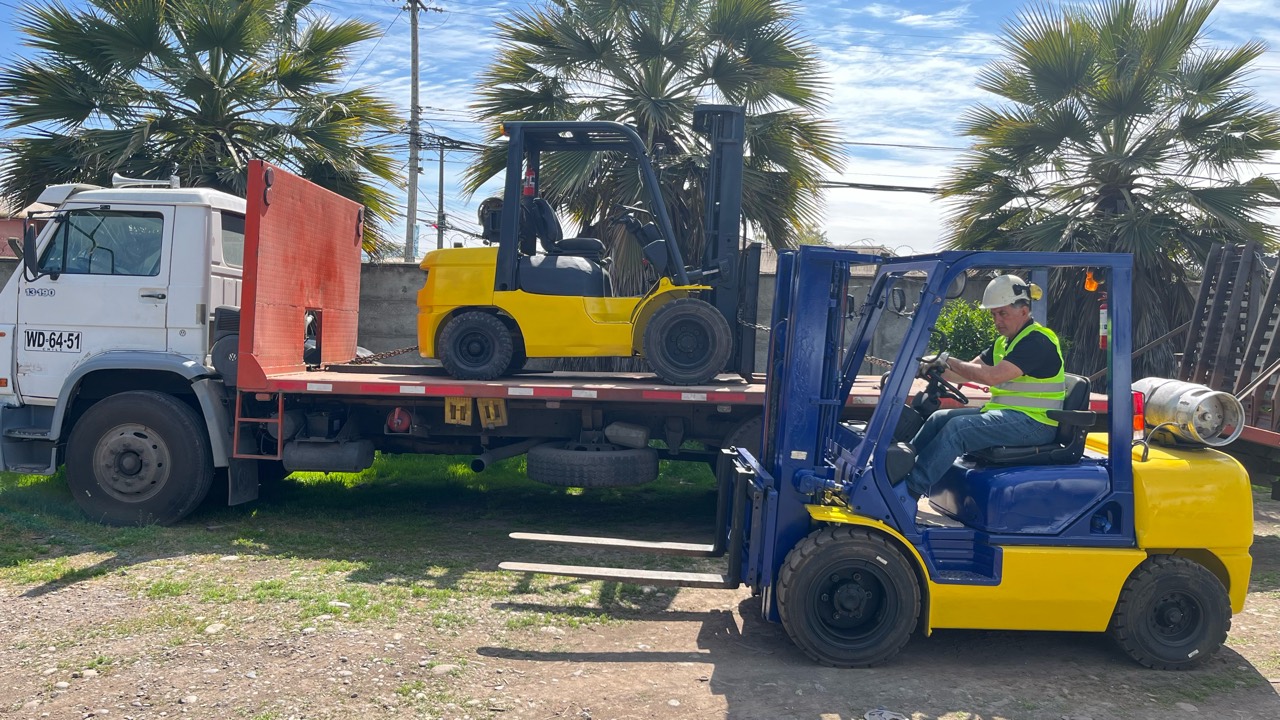 Operador con casco y chaleco reflectante en la grúa horquilla